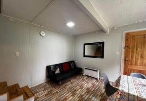a bedroom with a couch and a bed and a mirror at Sendero de Luna in Valdivia
