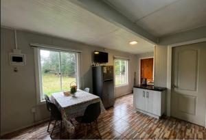 a kitchen with a table with chairs and a refrigerator at Sendero de Luna in Valdivia