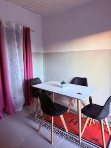 a table and chairs in a room with pink curtains at Logis Baobab in Morondava