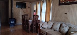 a living room with a couch and a wood stove at Cabaña con rio y camping in Los Ángeles