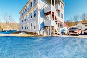 a large apartment building with a car parked next to it at Cozy Mountain Getaway in Proctorsville