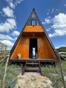 a large wooden house with a triangular roof at Cozy Lakefront Cabin - Myselim in Shkodër