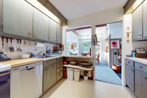 a large kitchen with white cabinets and a large window at Treetop Chalet in Peru