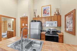 a kitchen with a sink and a refrigerator at Red Hawk Lodge #2308 in Keystone +20 photos