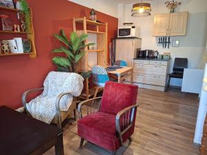 a kitchen with red walls and chairs and a table at Duplex au coeur d'Embrun in Embrun