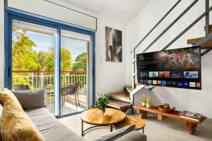 a living room with a couch and a tv at Royal Park Apartments Resort by Sea N Rent in Eilat