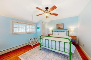 a bedroom with a green bed and a ceiling fan at The Cave Inn in Bomoseen +55 photos
