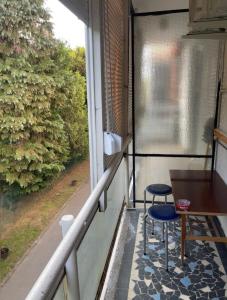 a balcony with two chairs and a table and a window at Willow Apartmant in Harkány