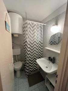 a small bathroom with a toilet and a sink at Willow Apartmant in Harkány