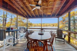 a screened porch with a table and chairs and a ceiling fan at Bomo Hacienda in Castleton