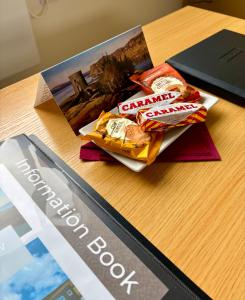 a table with a book and some food on it at Minch View Cabin 2, 1 Earlish in Earlish