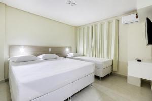 a white bedroom with a large white bed and a tub at WR Confort Hotel Campo Grande in Campo Grande +45 photos