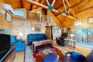 a living room with blue furniture in a cabin at Lake Bomoseen Log Cabin in Bomoseen