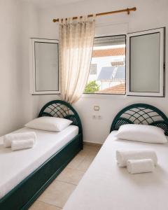 two beds in a room with two windows at SunsetApartment in Siviri