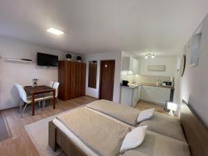 a bedroom with two beds and a table and a kitchen at Apartmany Star in Liptovský Mikuláš