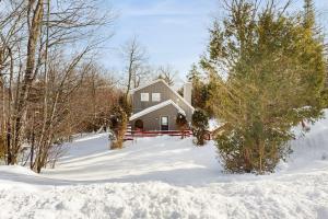 a house in the snow with trees and snow at Bear's Crossing Retreat in Dover