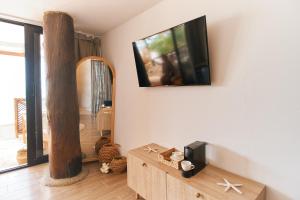 a living room with a tv on a wall at Marazao Beach Hotel & Wellness in Tierra Bomba