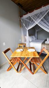 a wooden table in a room with a bed at Pousada Angelim in Santo Amaro
