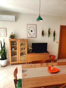 a living room with a table and a tv at Golden Hour House in Termoli