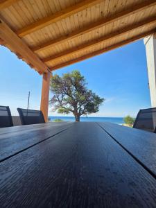 a wooden table with a tree on the beach at Asteria Houses Samothraki in Samothraki