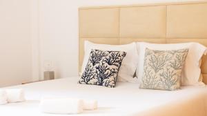 a bed with three pillows on it with at The Surf - Rocha Tower in Portimão +9 photos
