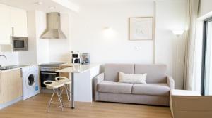 a living room with a couch and a chair in a kitchen at The Surf - Rocha Tower in Portimão
