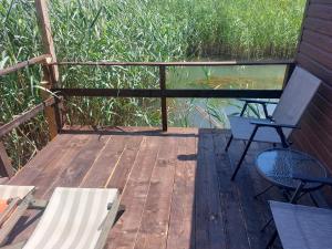 a wooden deck with two chairs and a table and a glass table at Apartman Dva Dječaka in Ulcinj +4 photos