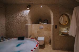 a bathroom with a large bath tub with a toilet at Gazel Cave House in Ürgüp +95 photos