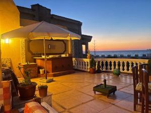 a patio with an umbrella and a view of the ocean at EL Fouly Villa beach front -North Coast فيلا لمة العيله الفولي - سيدي كرير - الساحل الشمالي in Abû Zeira