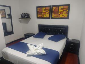 a bedroom with a bed with a flower on it at Hospedaje Luna Dorada in Manizales