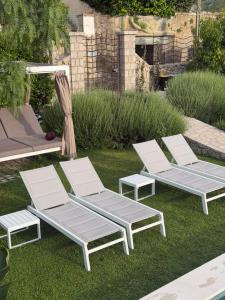a group of four lounge chairs sitting on the grass at Amamì B&B in Anacapri