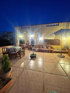 a patio with a table and chairs and an umbrella at EL Fouly Villa beach front -North Coast فيلا لمة العيله الفولي - سيدي كرير - الساحل الشمالي in Abû Zeira