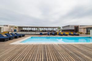 a swimming pool with blue chairs on a building at Lagoon Shoreline Penthouse in Cape Town +21 photos