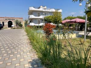 a brick walkway with plants in front of a building at Union Villa in Shkodër