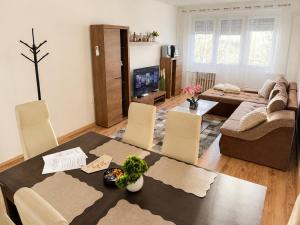 a living room with a table and chairs and a couch at Tildy Apartman Pécs in Pécs