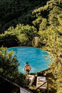 a woman walking in front of a swimming pool at Aura Toscana Boutique in Monsummano Terme