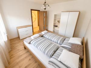 a room with a long couch with pillows on it at Tildy Apartman Pécs in Pécs