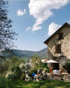 a house with chairs and tables in front of it at Maison De Fontale in Aleu