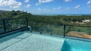 a swimming pool on the balcony of a house at Luxury Oceanview Condo Rooftop Infinity Pool in Las Terrenas