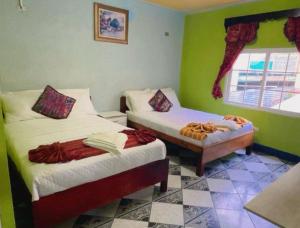 a room with two beds and a window at Apartamento el Amigo in Panajachel