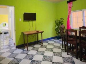 a living room with a table and a green wall at Apartamento el Amigo in Panajachel