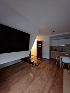 a living room with a large flat screen tv on a wall at Willa Kier dom bliźniak 7-osobowy ZE STREFĄ BASENOWĄ w miejscowości Chocznia NIEDALEKO ZATORU I ENERGYLANDII in Chocznia