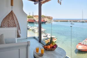 a table with a bowl of fruit on a balcony at Aqua Vero Seaside Residence in Hersonissos
