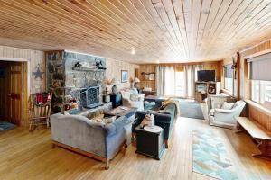 a living room with couches and a stone fireplace at Justin Lake Lodge in Londonderry
