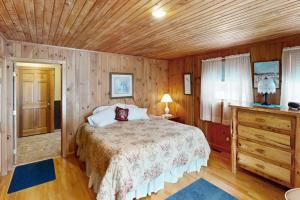 a bedroom with a bed and a wooden ceiling at Justin Lake Lodge in Londonderry