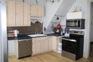 a kitchen with a sink and a stove and a microwave at The Polished Plank in Kokomo
