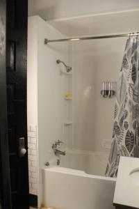 a bathroom with a bath tub with a shower at The Polished Plank in Kokomo +34 photos