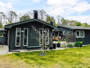 a green house with a bench in a yard at 4 star holiday home in SÖLVESBORG in Sölvesborg