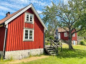 a red building with a staircase next to a tree at 4 star holiday home in TORHAMN-By Traum in Torhamn
