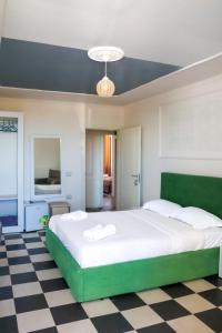a bedroom with a large white bed and a checkered floor at Esal Hotel in Durrës
